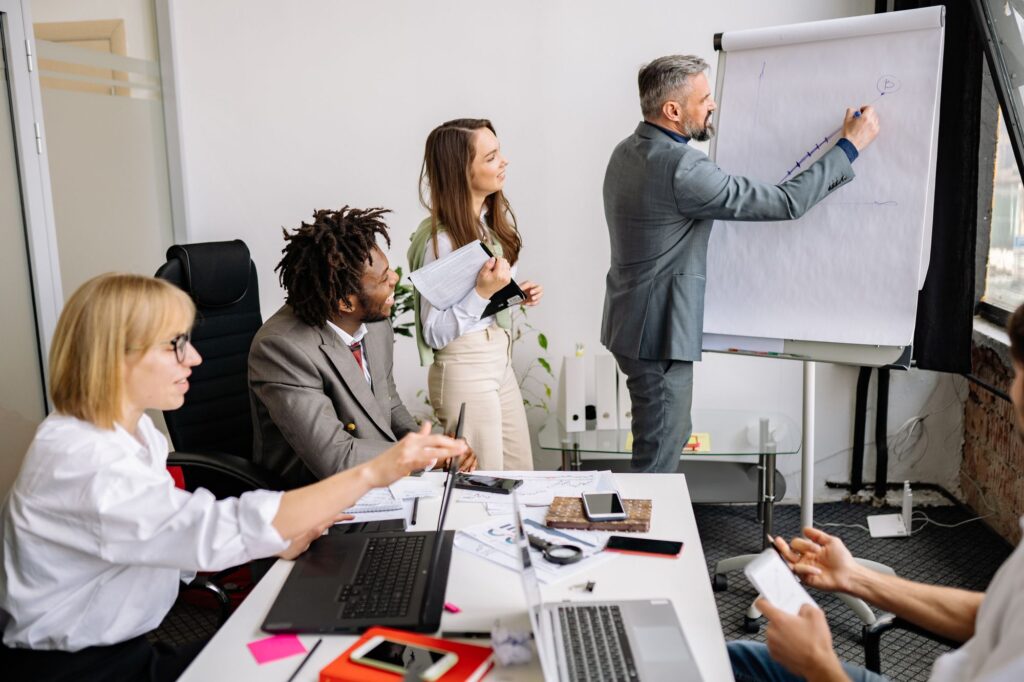 Führungskraft bespricht Change Management im Gespräch mit ihrem Team am Besprechungstisch