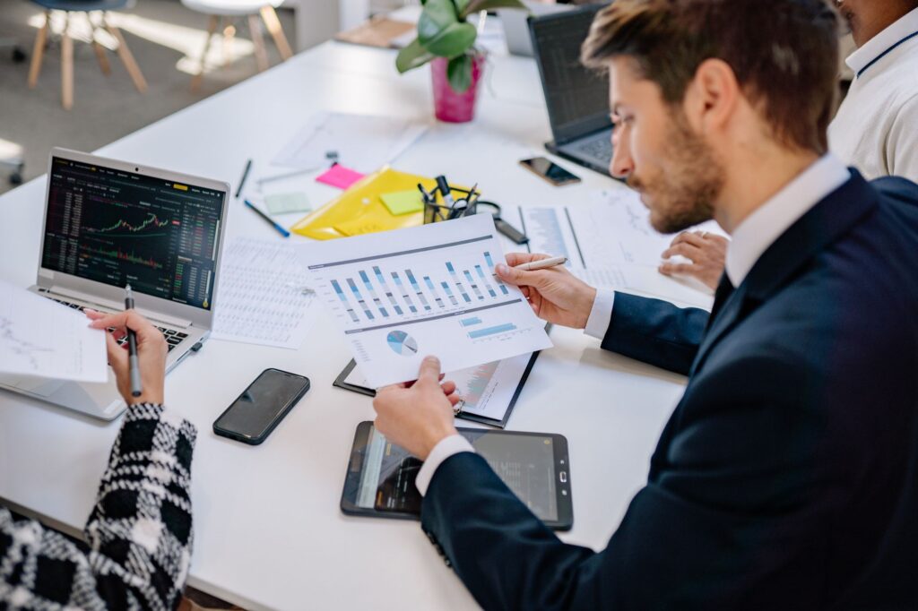 Finanzchef analysiert Zinsänderungsrisiko mit Unterlagen und Charts am Schreibtisch