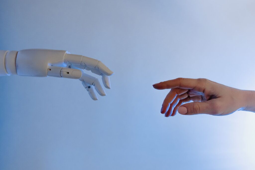 Risikoklassen im AI Act: Person streckt die Hand nach einem Roboter aus