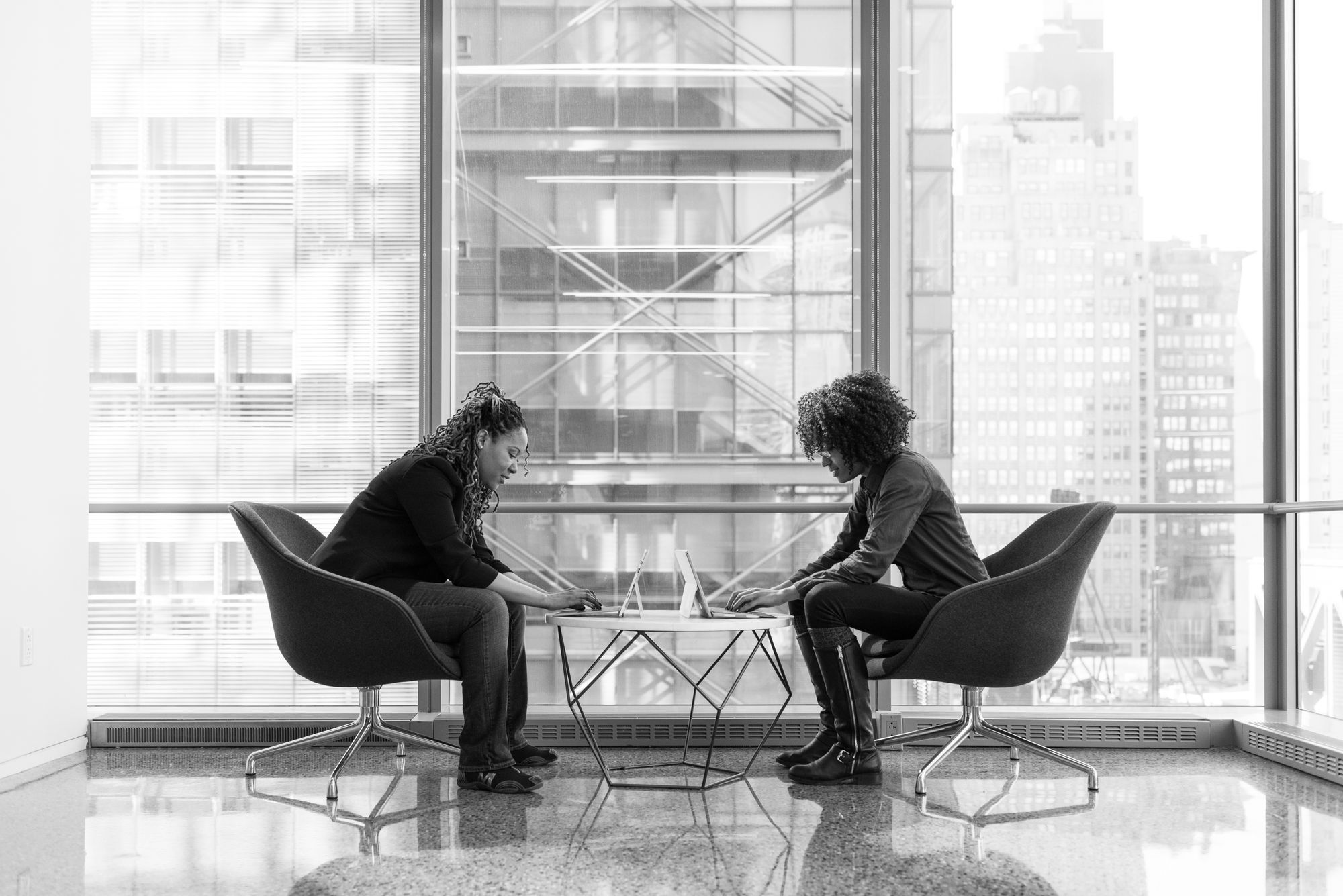 BEM-Gespräch: Zwei Frauen im Gespräch an einem Tisch in einem modernen Büro