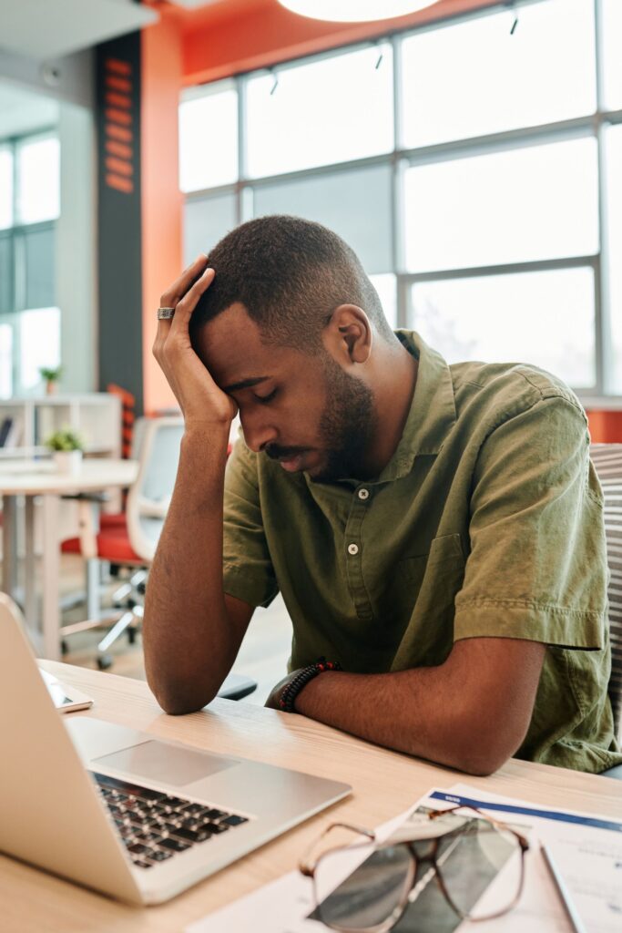 Müder Mann im Büro nach einem langen Tag an der Grenze der Höchstarbeitszeit