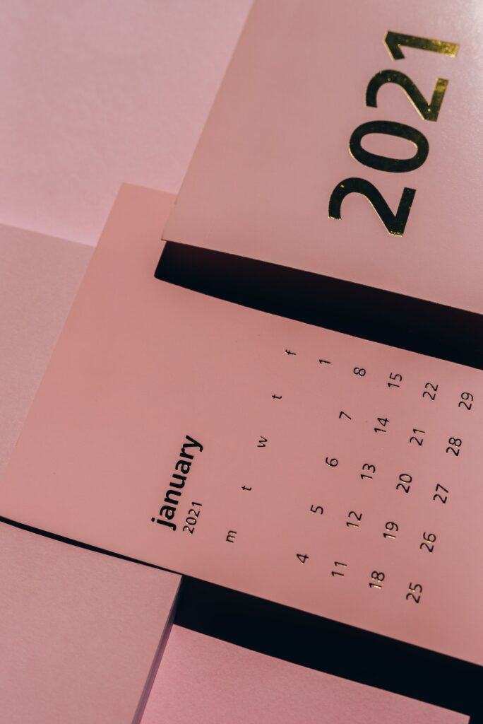 Papierkalender mit Wochendaten auf dem Schreibtisch zur Planung von Urlaubsanspruch