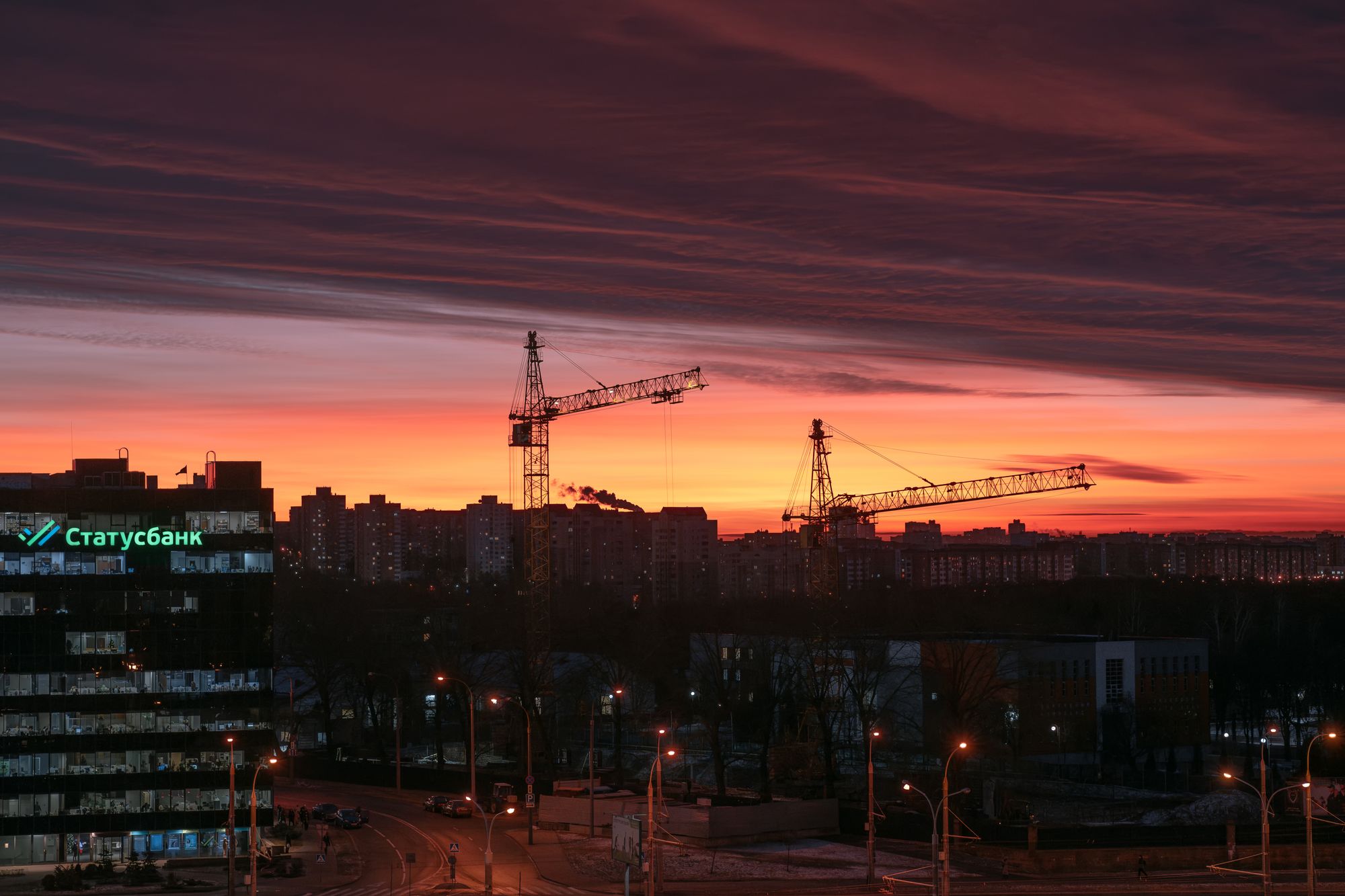 Baukräne in der Skyline einer Stadt in der Dämmerung, Bau profitiert von einer Zinssenkung